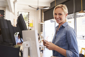 Portrait Of Waitress At Cash Register In Coffee Shop