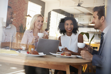 Businesspeople Meeting In Coffee Shop Shot Through Window