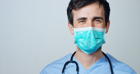 close up portrait of a surgeon or doctor with mask and headset ready for operation in hospital or clinic. The surgeon smiles safe and proud of himself. Concept of medicine, hospitals and doctors, care