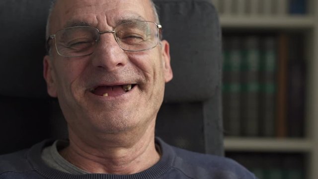 old man laughs out loud close up