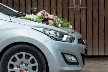 Floral decoration on gray wedding car bonnet.
