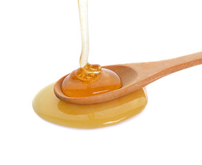 Honey on wooden spoon  isolated on white background