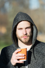 man in hoodie with paper coffee, tea cup