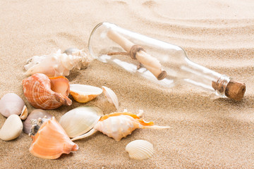 Message in bottle on the beach. Summer background with hot sand