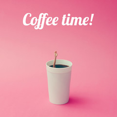 Coffee cup with female doll hand on pink background. Coffee concept.