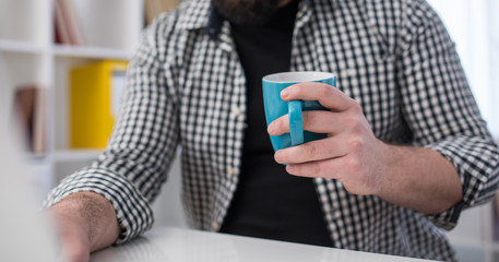 Man holding a coffee mug, part of