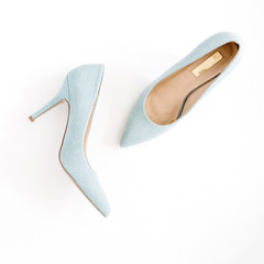 Beauty blog concept. Pale blue female shoes on white background. Flat lay, top view trendy fashion feminine background.
