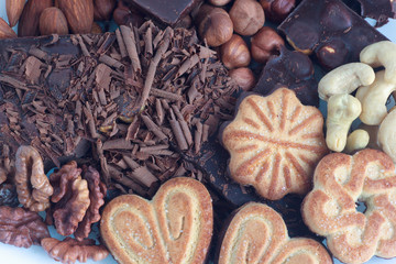 Chocolate,cookies and nuts lying on the dinner table.