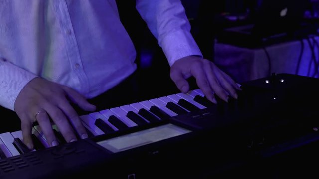 Closeup shot of keyboardist male hand playing synthesizer at party. 4k UHD video