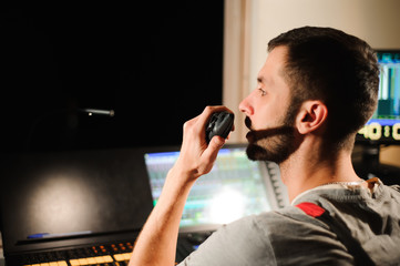 A lighting engineer works with lights technicians control on the concert show. Professional light...
