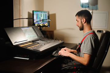 A lighting engineer works with lights technicians control on the concert show. Professional light...