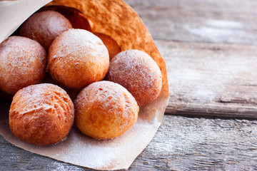 Freshly made donuts from cottage cheese with powdered sugar in a paper bag, copy space
