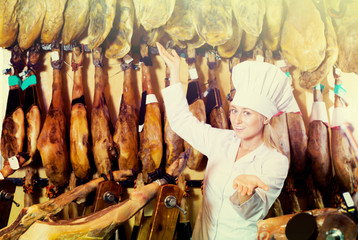 Fototapeta na wymiar Glad female selling prosciutto meat