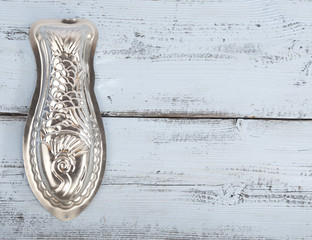 Silver fish baking mold on wooden background