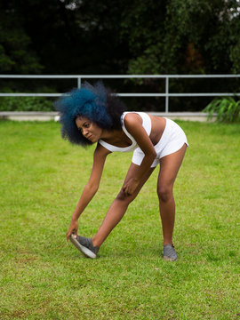 Mulher negra alongando as pernas ao ar livre