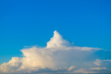 Naklejka na ściany i meble Cloud in the shape of cake or boat against blue sky.