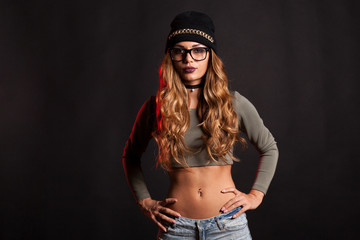 Sexy woman with jeans shorts on black background in studio photo