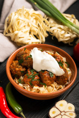 Meat balls with tomato sauce and pasta, close-up