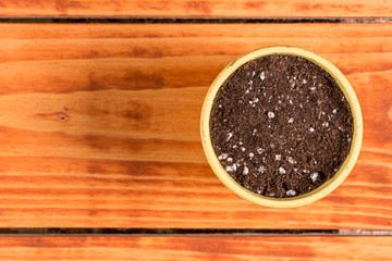 Flat lay above flower pot with soil for seeding plants