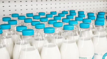 bottles with milk as dairy product for preparing breakfast wait for byers on market shelf