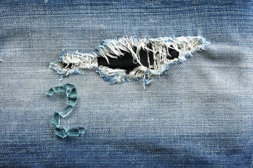 Blue denim vintage jeans in dark color in the scene present the broken tempered grass arrangement the number on the old damaging fabric texture background.