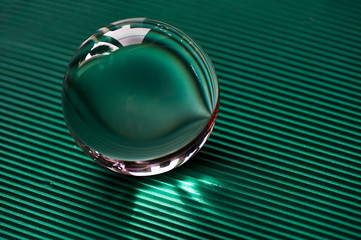 Glass globe or drop of water on a background of green corrugated paper . Clean and Shine