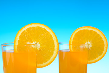 Two glasses of orange juice on the beach
