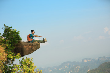 successful woman hiker enjoy the view on mountain peak cliff