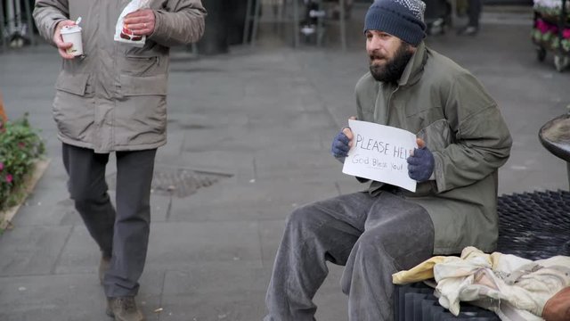 old gentleman brings breakfast to a homeless caressing his face