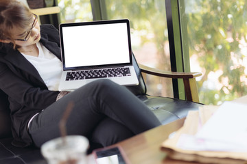 Asian woman using laptop and presenting with blank screen laptop  in selective focus.