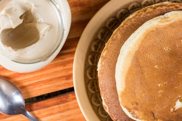 Flat lay above american pancakes with bowl of chocolate cream