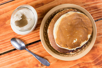 Flat lay above american pancakes with bowl of chocolate cream