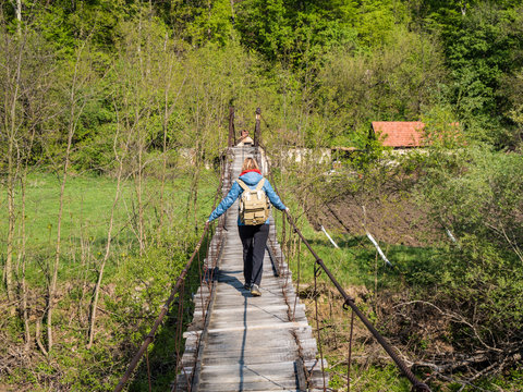 Woman crossing wooden bridge on hike path in National Park