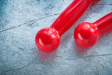 Red dumbbells on silver background top view sports training conc