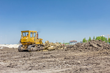 Heavy earthmover construction machine is moving earth at building site