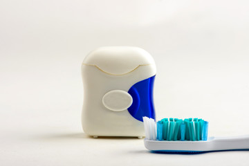 Fototapeta na wymiar toothbrush and dental floss on white background
