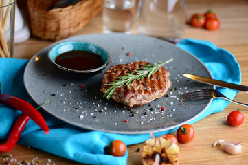 Juicy steak on an plate with sauce served for a dinner in a steakhouse. Food background.
