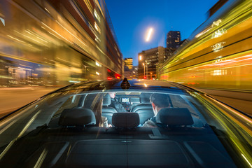 Fototapeta na wymiar Taxi Driver Riding Couple On City Street At Night