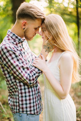 Fototapeta premium Beautiful Love story in the woods. Portrait of young stylish couple.