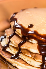 Pile of american pancakes with melting chocolate cream closeup macro