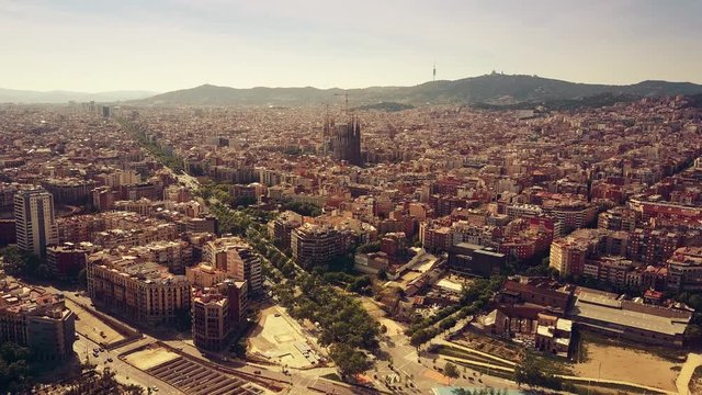 Barcelona cityscape and distant mountains on a sunny day, Spain. 4K aerial shot