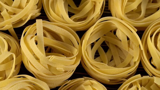 Raw unprepared pasta on wooden board.