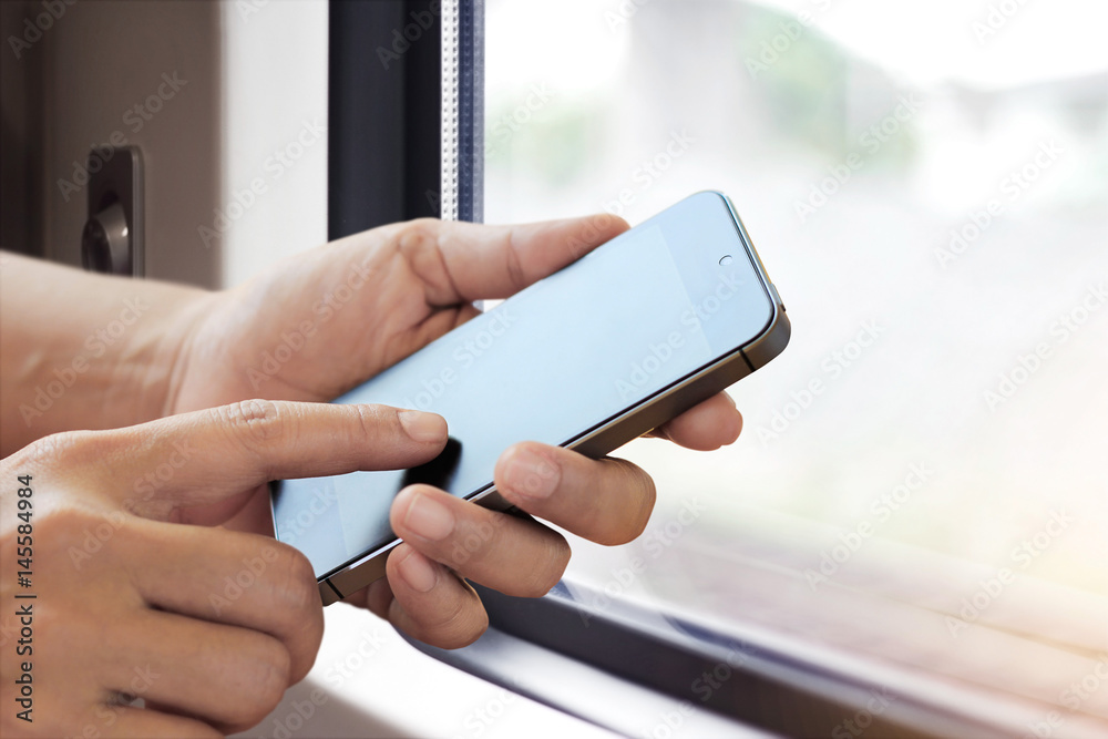 Poster hands holding smart phone on window of a train background