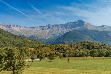 Fototapeta na wymiar Motion picture - Travelling by bus in Italian Alps - Alpine landscapes with motion-blurred foreground Highly in mountains at hot shiny summer day with blue cloudy sky.