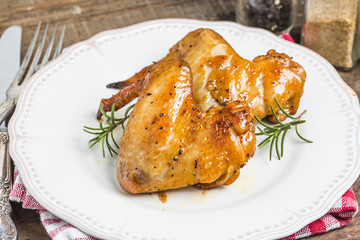 Baked chicken wings in pan on wooden table.