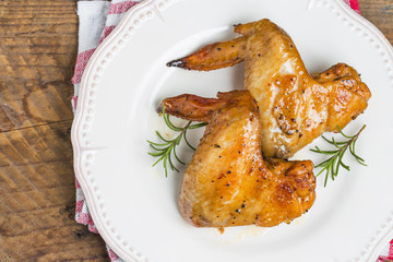 Baked chicken wings in pan on wooden table.