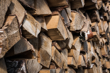 Natural wooden background, closeup of chopped firewood. Firewood stacked and prepared for winter.