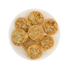 Top view of mini cheese pizza bagels on a plate isolated on a white background.