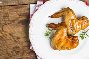 Baked chicken wings in pan on wooden table.