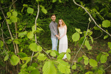 Beautiful Love story in the woods. Portrait of young stylish couple.